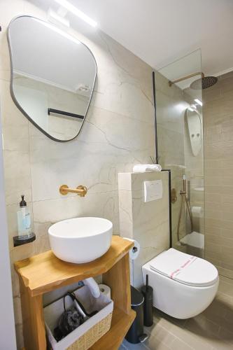 a bathroom with a sink and a toilet and a mirror at Makaros Nissos City in Mytilene