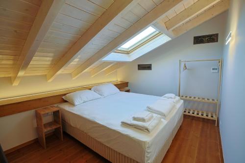 a bedroom with a white bed with a skylight at Makaros Nissos City in Mytilene