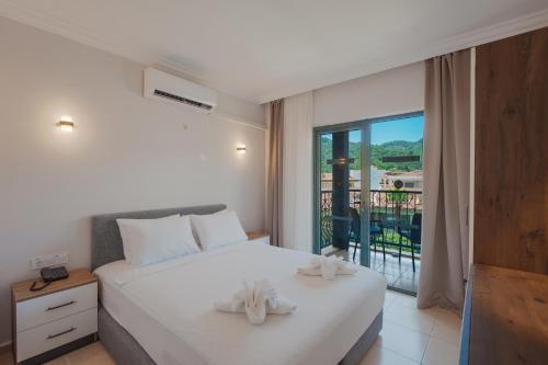 a bedroom with a bed with two white towels on it at 7 Brothers Hotels in Marmaris