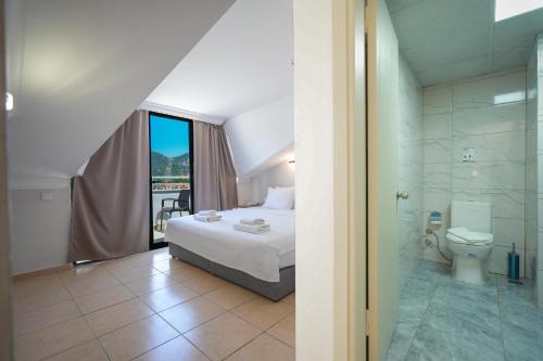 a bedroom with a bed and a bathroom with a shower at 7 Brothers Hotels in Marmaris