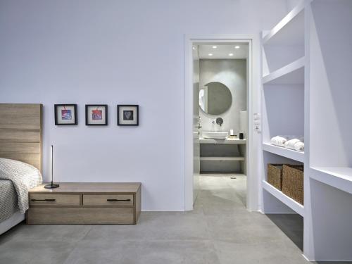 a bedroom with a bed and a bathroom with a mirror at Blue Mare Villas in Naousa