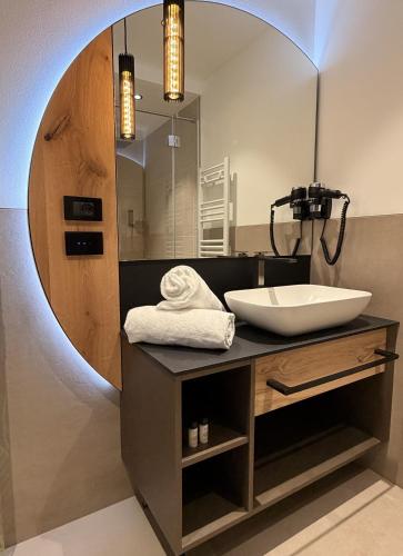 a bathroom with a sink and a mirror at Alpen Relais in Fondo
