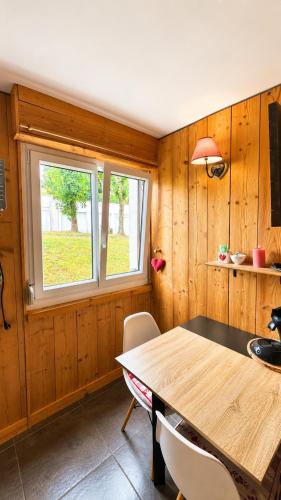 a dining room with a table and a window at Logicoeur in Gérardmer