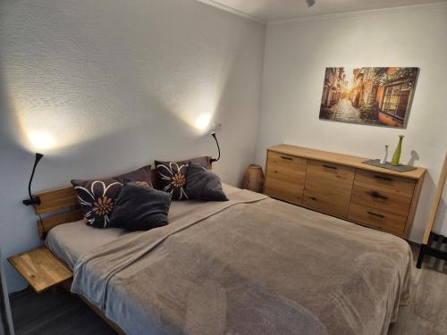 a bedroom with a large bed and a dresser at Ferienwohnung im ehemaligen Gesindehaus in Welschbillig