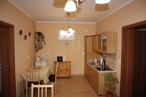 a kitchen with a table and a dining room at Kiserdő Vendégház in Rajka