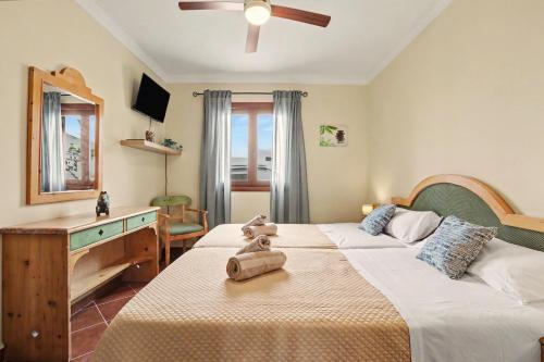 a bedroom with two beds with a dresser and a desk at Rincón de Daute in Los Silos