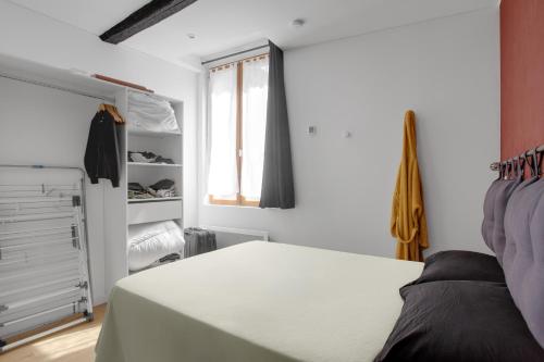 a white bedroom with a bed and a closet at O'soleil in Fréjus
