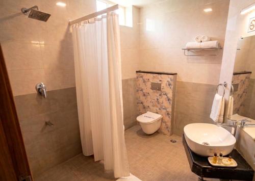 a bathroom with a shower and a toilet and a sink at Taika Hotels, 1km Away from Main Temple in Rāmeswaram