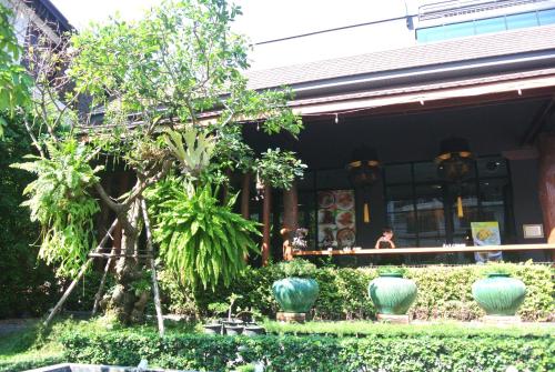 a building with green plants and vases in front of it at Le Naview @Prasingh in Chiang Mai