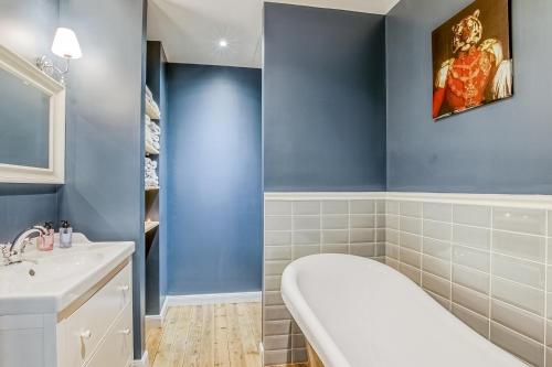 a bathroom with a white sink and blue walls at Gîte des Ducs de Guise - vue sur le Château fort in Guise