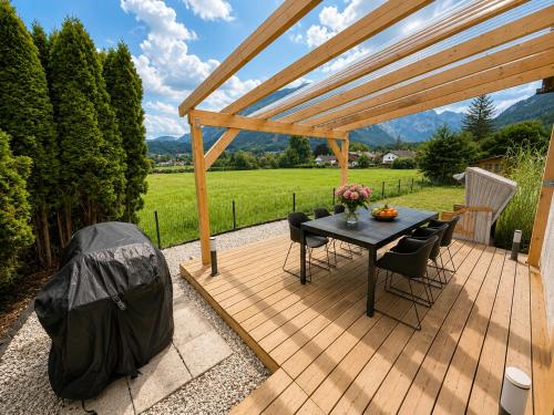 a patio with a table and chairs on a wooden deck at Alpzeit Ferienwohnung in Bayerisch Gmain