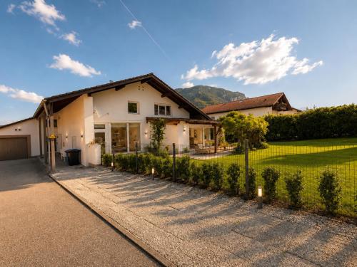a white house with a fence and a yard at Alpzeit Ferienwohnung in Bayerisch Gmain