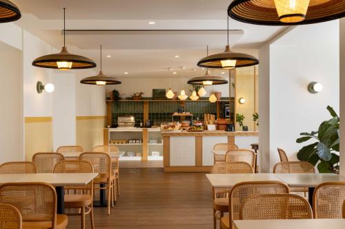 a restaurant with tables and chairs and a kitchen at Hôtel Kemaris in Biarritz