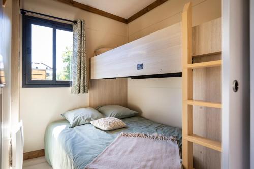 a small bedroom with a bunk bed in a tiny house at Camping les vergers de Squividan *** in Tréffiagat