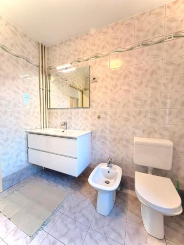 a bathroom with a white sink and a toilet at Central Townhouse with Parking in Ljubljana