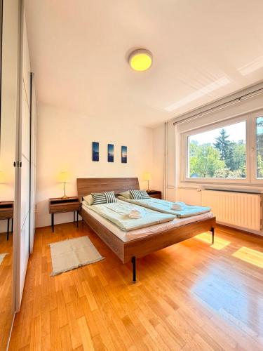 a bedroom with a large bed and a large window at Central Townhouse with Parking in Ljubljana