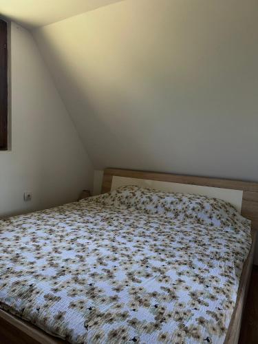 a bedroom with a bed with a floral comforter at Vikendica Jagoš in Mitrovac