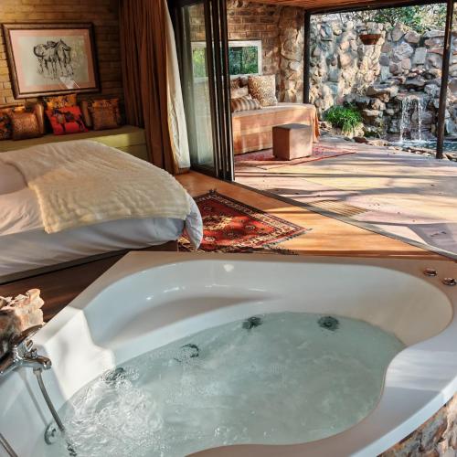 a bath tub in a room with a bedroom at Lethabo Estate in Lanseria