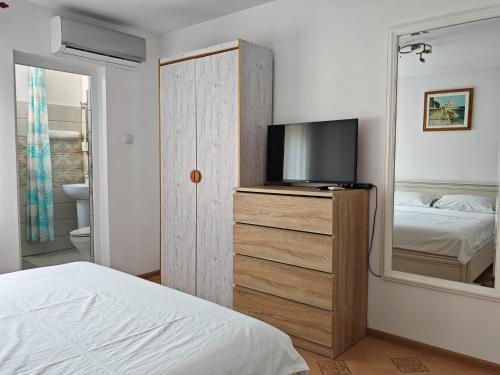 a bedroom with a bed and a tv and a mirror at Miri's House in Eforie Sud