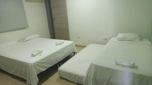 two beds sitting next to each other in a room at Oasis in Valledupar