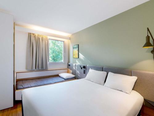 a bedroom with a large white bed and a window at ibis Nancy-Brabois in Vandoeuvre-lès-Nancy