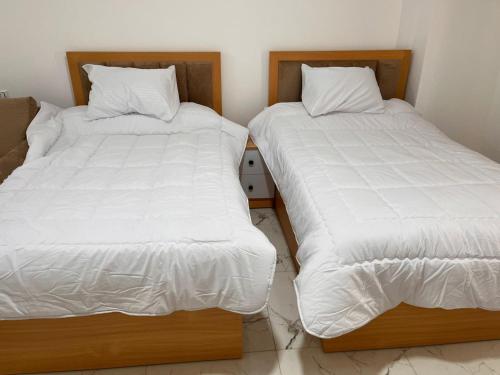 two beds sitting next to each other in a room at Lavanda Beach Resort Studio - Panoramic Sea & Pool View in Abū Rudays