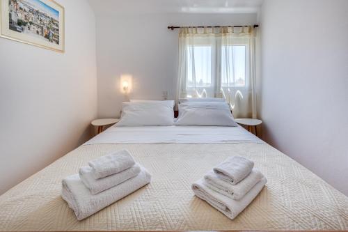 a bedroom with a bed with two towels on it at Apartmani Katica in Diklo
