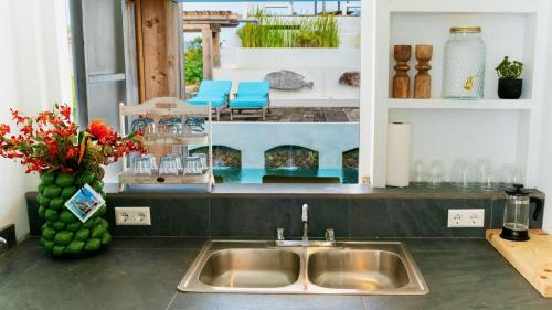 a kitchen sink with a view of a pool at Whale Tails Island Suites & Villas in Oranjestad