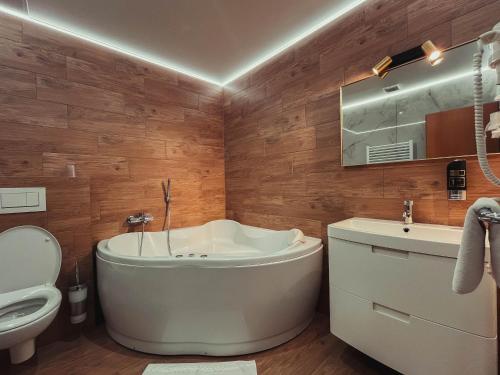a bathroom with a tub and a toilet and a sink at Hotel Roháč in Trstená