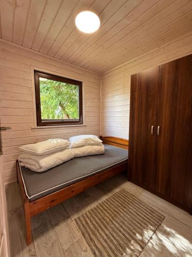 a small room with a bed in a cabin at Wakacje Bobolin in Bobolin