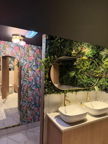a bathroom with two sinks and a mural of flowers at The Manor House Hotel in Dronfield