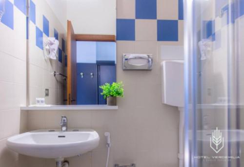 a bathroom with a sink and a mirror and a shower at Verdemilia Hotel in Anzola dell'Emilia