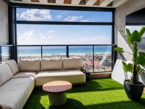 a living room with a couch and a large window at דירת החלומות באשדוד in Ashdod