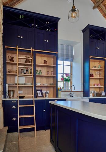 a kitchen with navy blue cabinets and a sink at The Studio in Castle Bytham