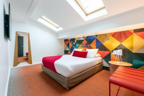 a hotel room with a bed and a red bench at Appart Hôtel Clément Ader in Toulouse