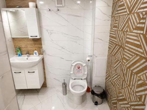 a white bathroom with a toilet and a sink at Apartment Underground, Premium Apartment in Ruse City Centre in Ruse