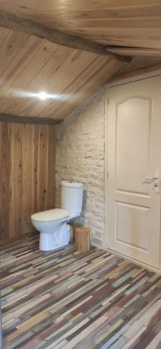 a bathroom with a toilet and a door at Le Gîte et le Couvert in Bellefoye