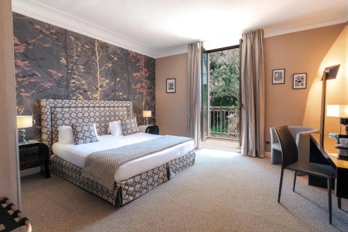 a bedroom with a bed and a large window at Le Mas de Guilles in Lourmarin