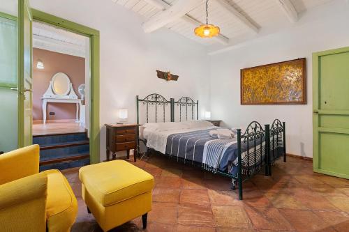 a bedroom with a bed and a chair and a mirror at Case Saponara in Cefalù