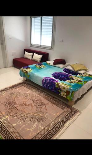 a large bed in a room with a rug at Appartement Hergla in Harqalah