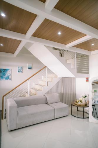 a living room with a couch and stairs at Palms La Union Beachfront Suites in San Juan