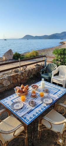 a table with food on it next to the water at Eroico sul Mare in Portoferraio