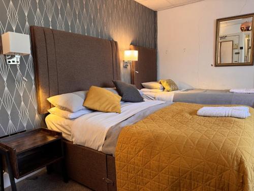 a hotel room with two beds and a mirror at Charde Guest House in Birmingham
