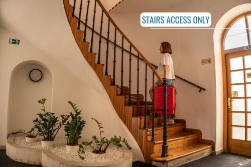 a woman walking down the stairs with a suitcase at BlueBell Hotel in Bratislava