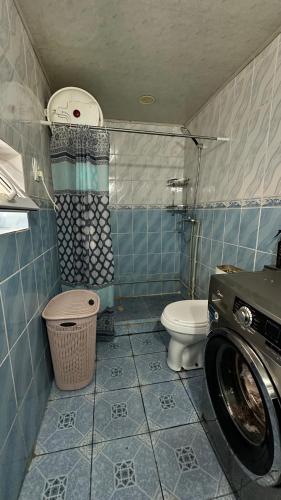 a bathroom with a toilet and a washing machine at datkaguesthouse in Kochkorka