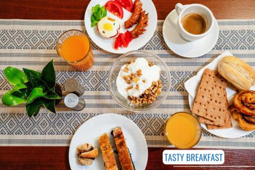 a table with plates of breakfast food and a cup of coffee at BlueBell Hotel in Bratislava