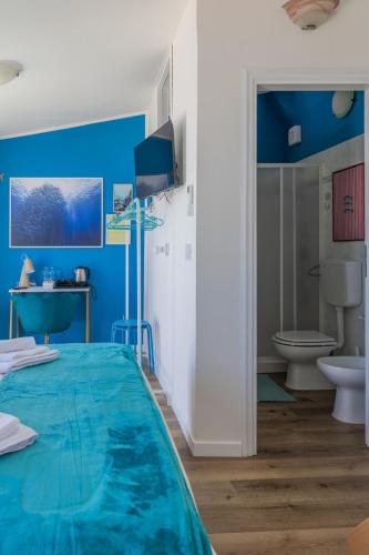 a blue room with a bed and a toilet at Chianalea Guesthouse in Scilla