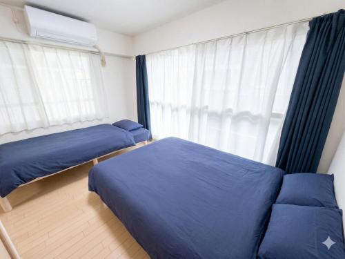 a bedroom with two beds and a window at メゾンドアトール in Sapporo