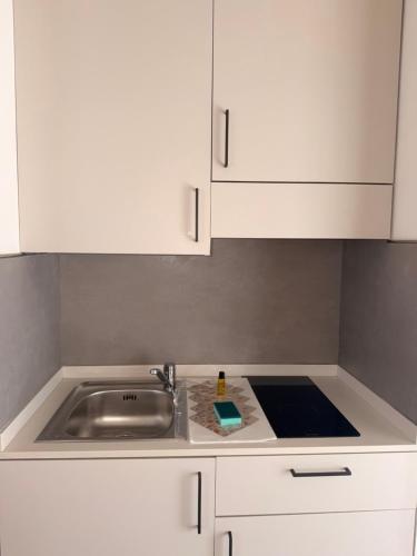 a kitchen with white cabinets and a sink at Riviera Residence in Rimini