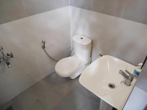 a bathroom with a white toilet and a sink at Hotel J'S Heritage in Kodaikānāl